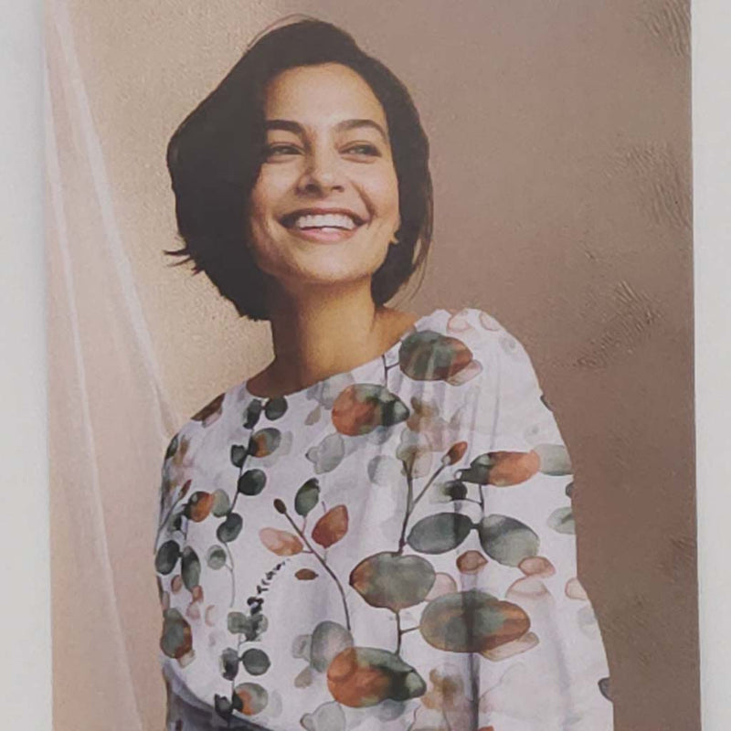 Woman wearing a floral blouse with a neutral background