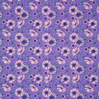 A vintage floral design featuring pink flowers on a lilac polycotton fabric