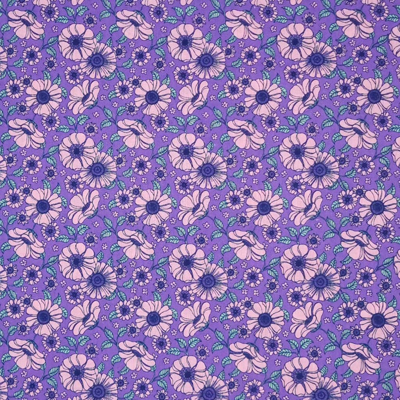 A vintage floral design featuring pink flowers on a lilac polycotton fabric