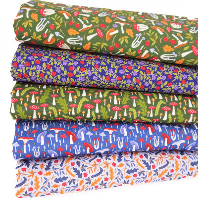 A fat quarter bundle featuring mushrooms and toadstools printed on forest green and blue cotton fabrics