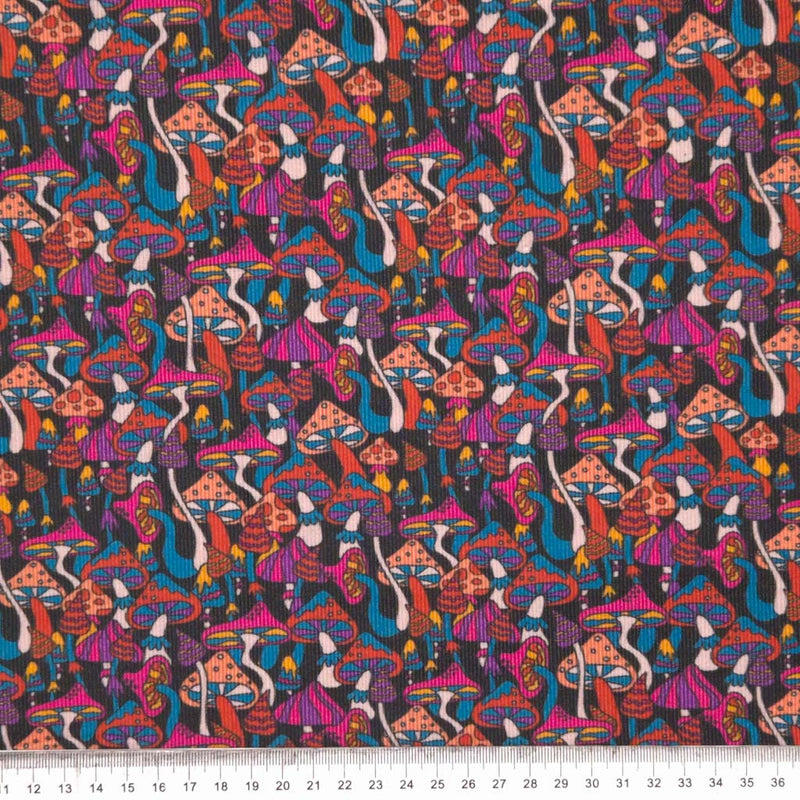 Psychedelic mushrooms printed on a black cotton needlecord fabric with a cm ruler