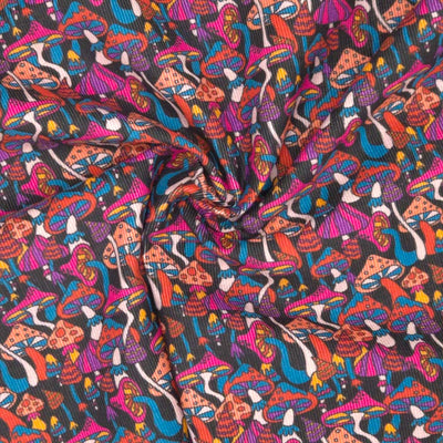 Psychedelic mushrooms printed on a black cotton needlecord fabric in a swirl