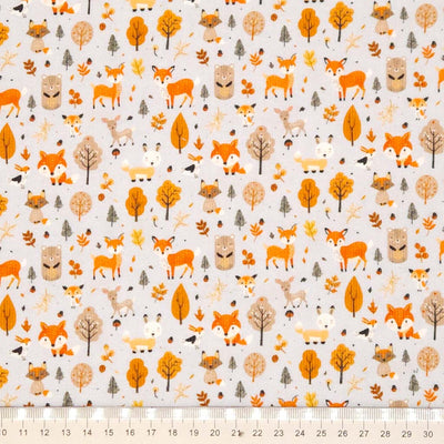 Pattern of foxes, deer, and trees on a grey needlecord fabric with a cm ruler