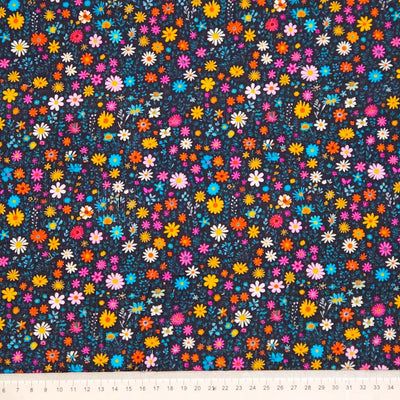Colorful floral pattern on a dark needlecord fabric with a cm ruler