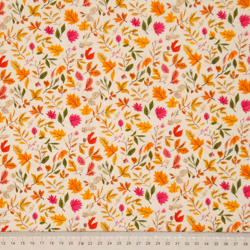 Fabric with autumn leaf pattern on a beige background, ruler at the bottom for scale.