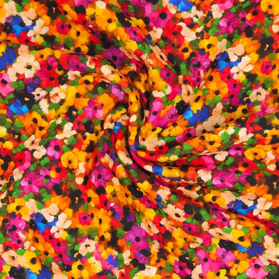 Colourful needlecord fabric with a pattern of small flowers in various colors.