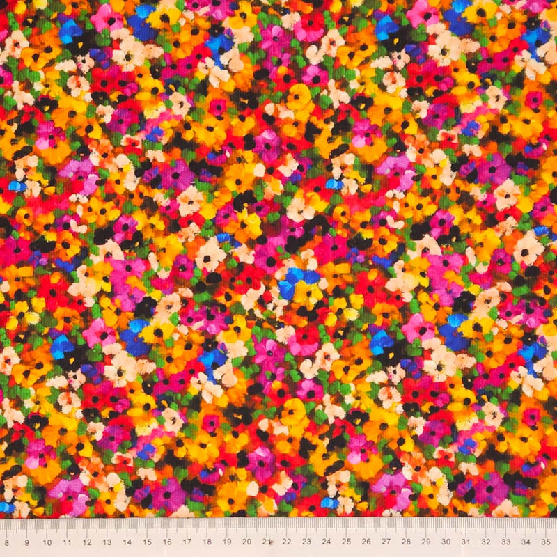 Multicolored floral pattern on a needlecord fabric with a cm ruler