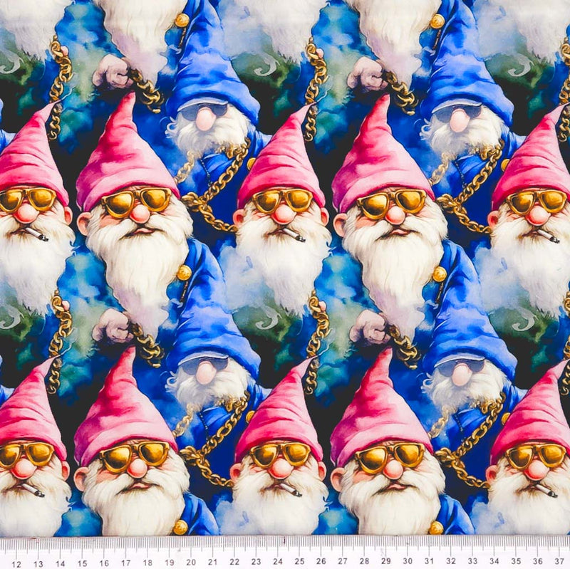 Pattern of gnomes with pink hats and gold sunglasses on a blue cotton fabric with a ruler at the bottom.