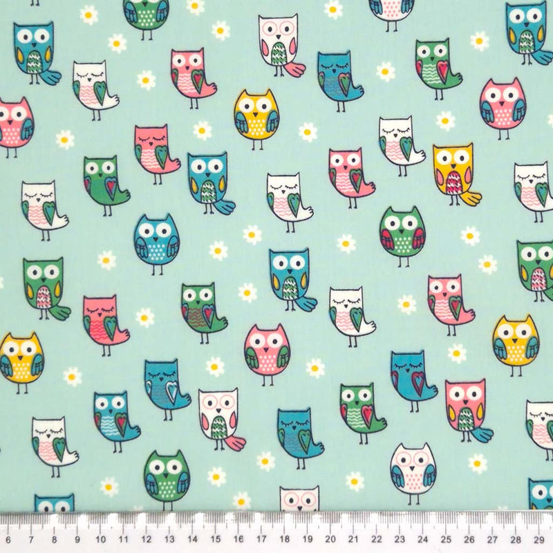 Owls printed on a mint cotton poplin fabric with a cm ruler