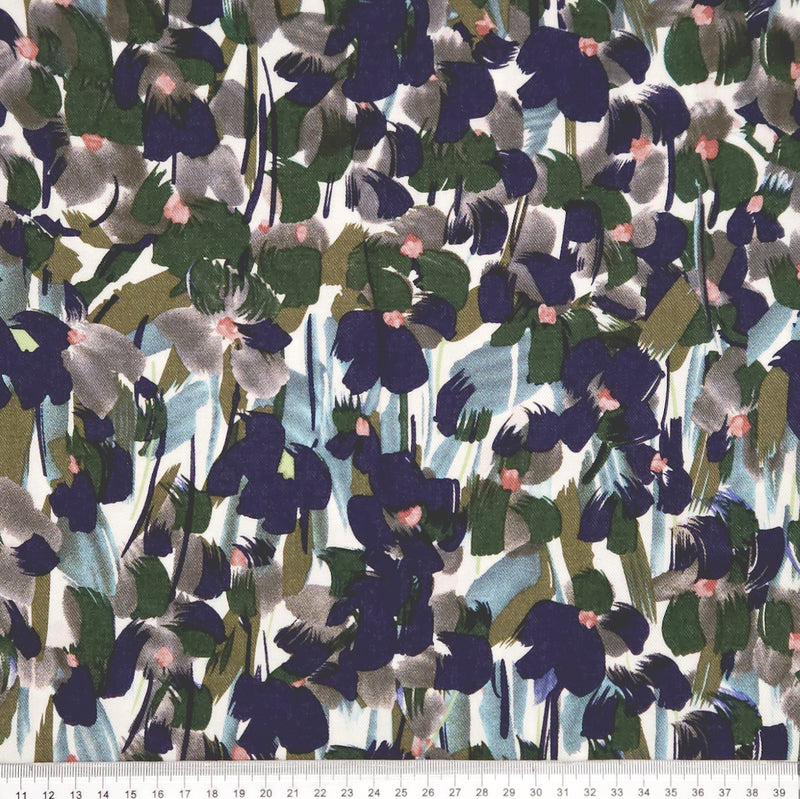 Pattern of abstract shapes in various colours on a white viscose fabric with a cm ruler