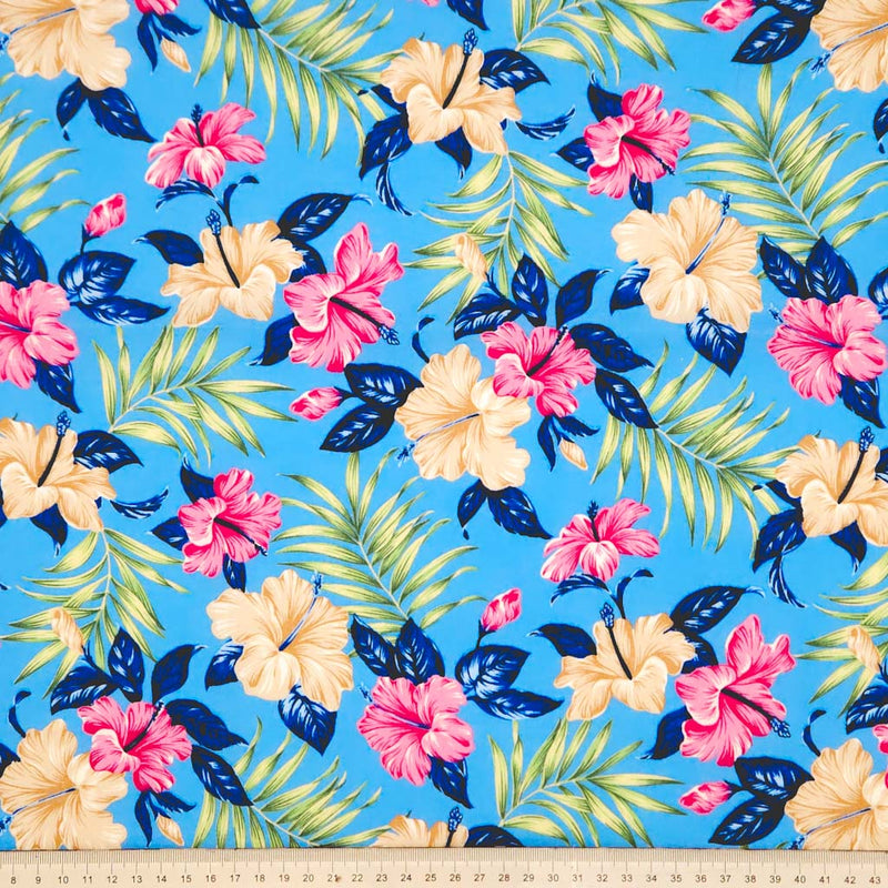 Hibiscus flowers printed on a sky blue cotton poplin fabric with a cm ruler