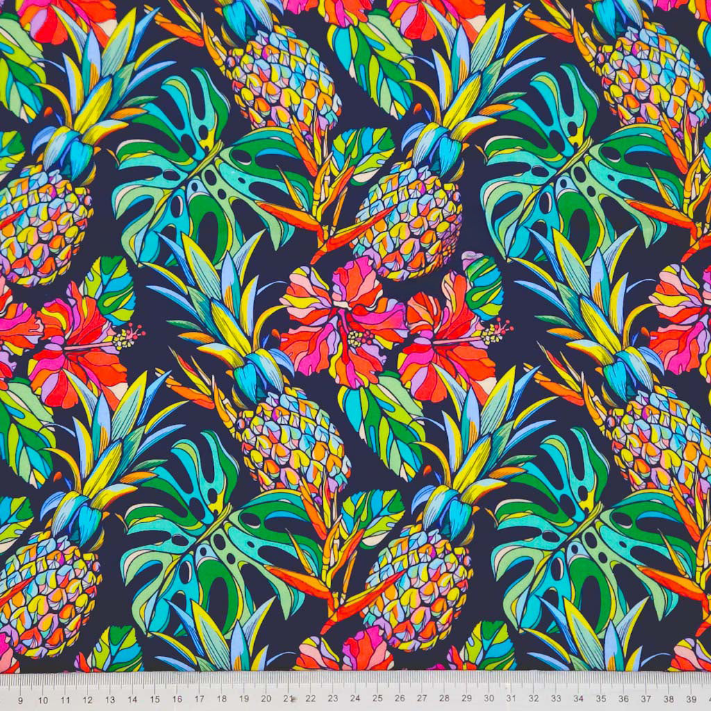 Pineapple and hibiscus printed on a navy cotton poplin fabric with a cm ruler