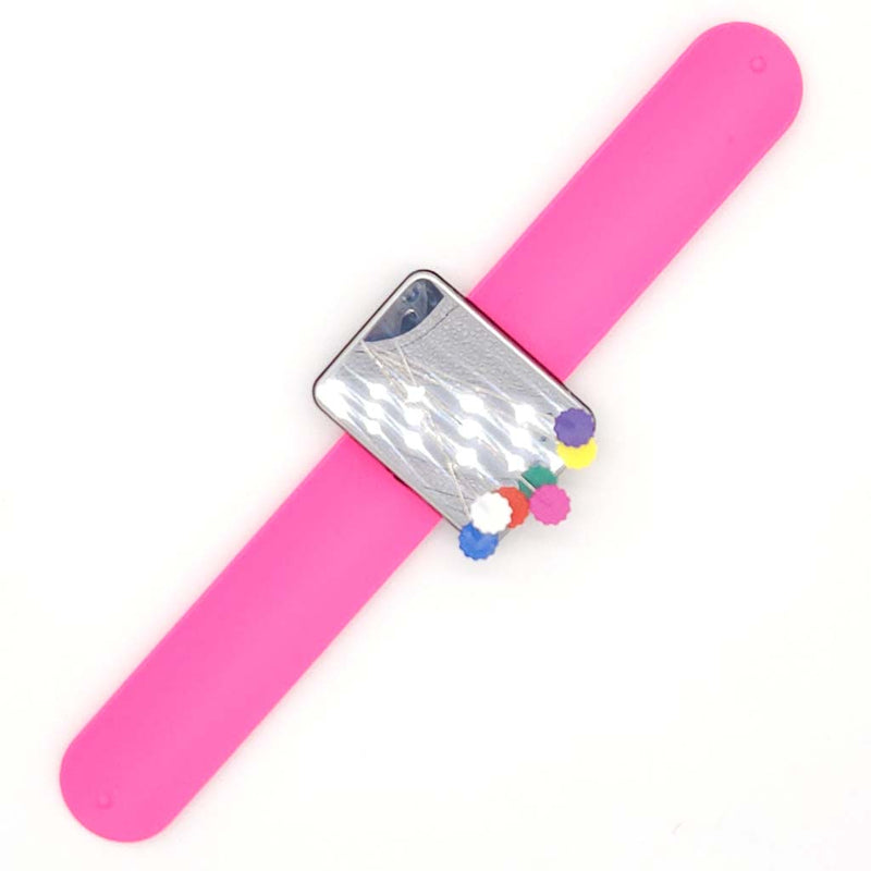 Pink slap bracelet with a silver clasp and colourful pins on a white background