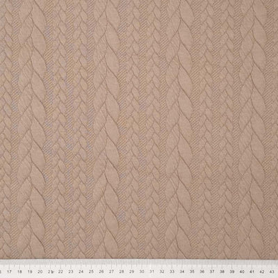 A plain sand coloured cable knit fabric with a cm ruler
