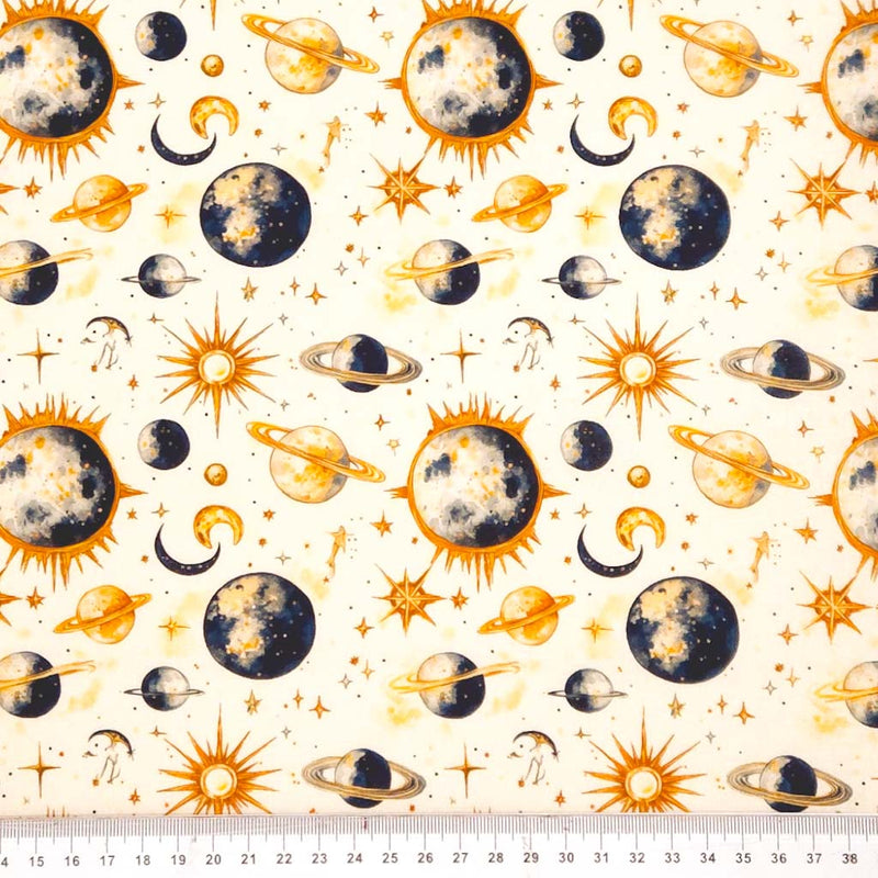 Pattern of celestial bodies including planets, stars, and suns on a white cotton fabric with a ruler at the bottom.