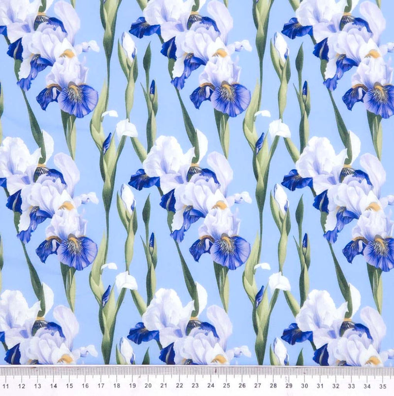 Pattern of blue and white flowers on a light blue polycotton fabric with a ruler at the bottom.