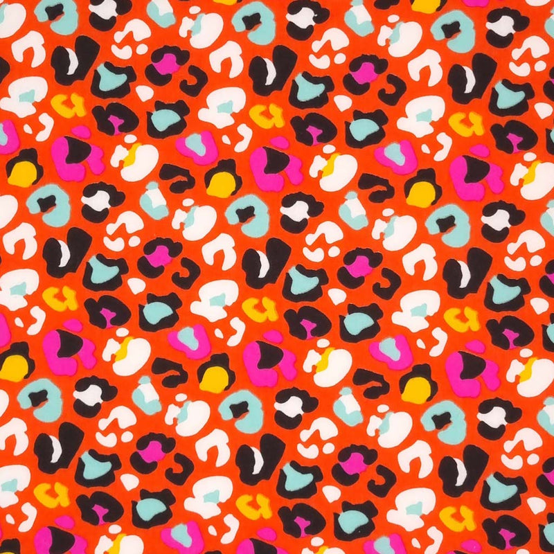 A fun leopard print with colourful leopard spots on an orange polycotton