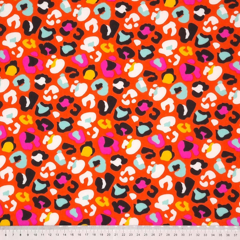 A fun leopard print with colourful leopard spots on an orange polycotton with a cm ruler