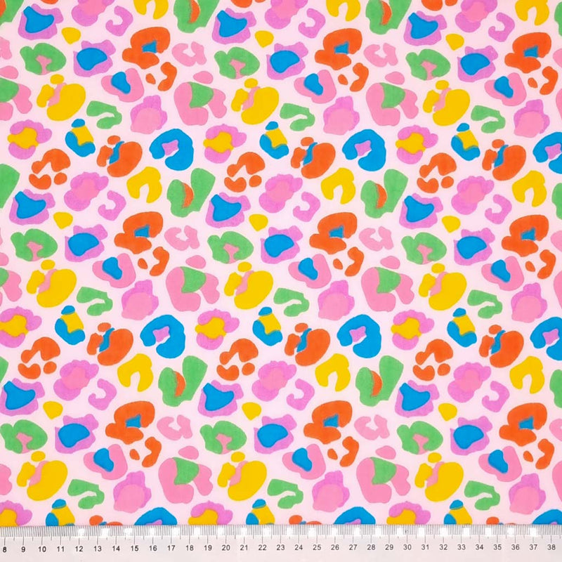 A fun leopard print with colourful leopard spots on a pink polycotton with a cm ruler