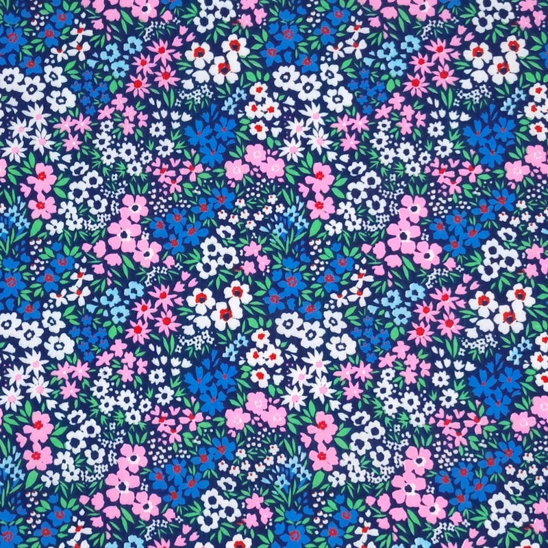 Ditsy flowers in pinks and blues are printed on a navy polycotton fabric