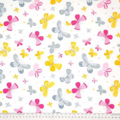 Cerise, grey and yellow butterflies printed on a white polycotton fabric with a cm ruler