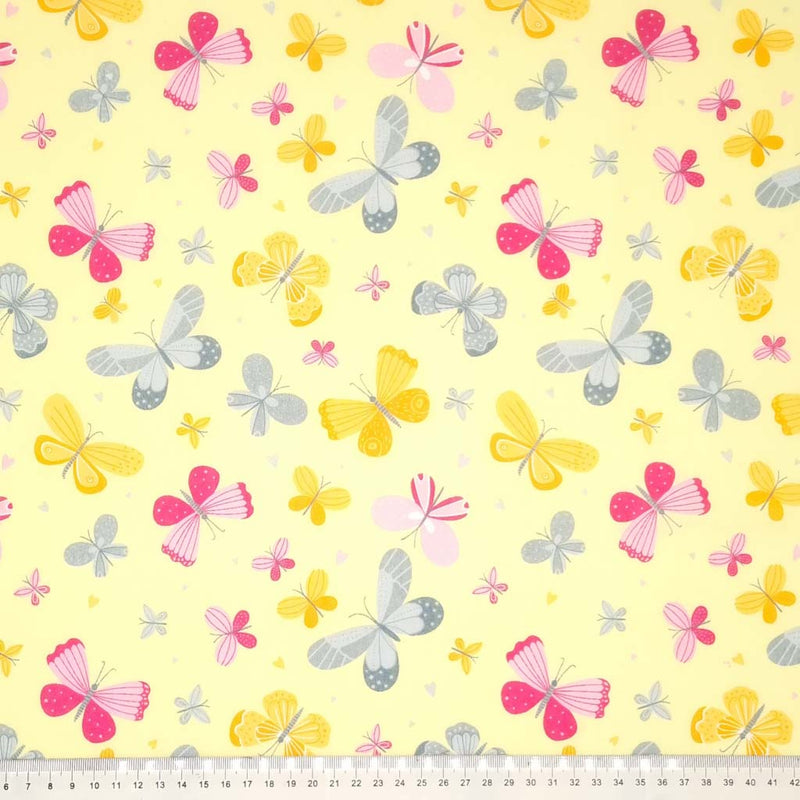 Cerise, grey and yellow butterflies printed on a yellow polycotton fabric with a cm ruler