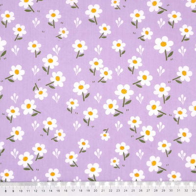 Pretty white daisies are printed on a lilac polycotton fabric with a cm ruler
