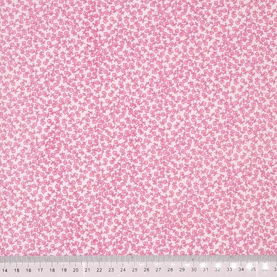 Ditsy pink flowers printed on a white polycotton fabric with a cm ruler