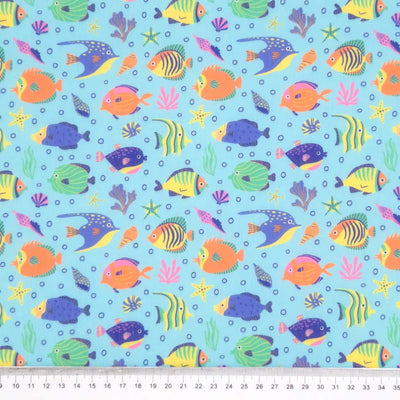 Tropical fish printed on a sky blue polycotton fabric with a cm ruler