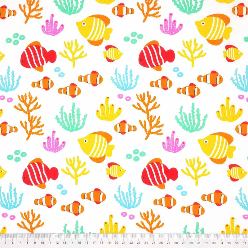 Brightly coloured stripey fish are printed on a white polycotton fabric with a cm ruler