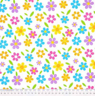 Brightly coloured flowers are printed on a white polycotton fabric with a cm ruler