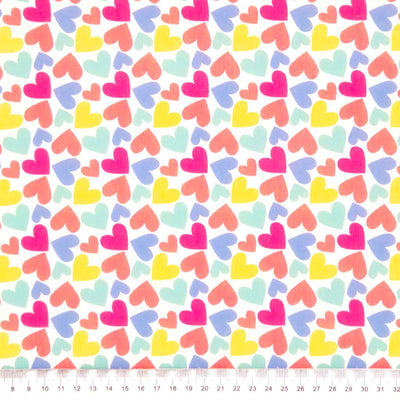 Coloured hearts printed on a white polycotton fabric with a cm ruler
