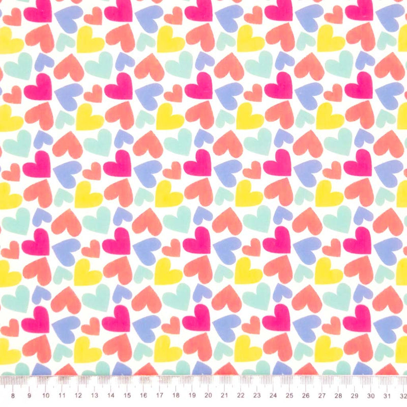 Coloured hearts printed on a white polycotton fabric with a cm ruler