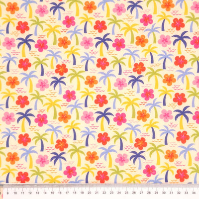 Palm trees and hibiscus printed on a cream polycotton fabric with a cm ruler