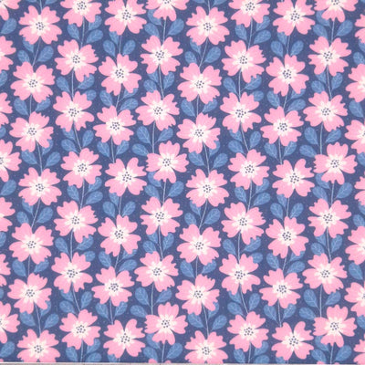 Baby pink and white flowers strung together by dusk blue vines on a night-sky blue polycotton fabric.