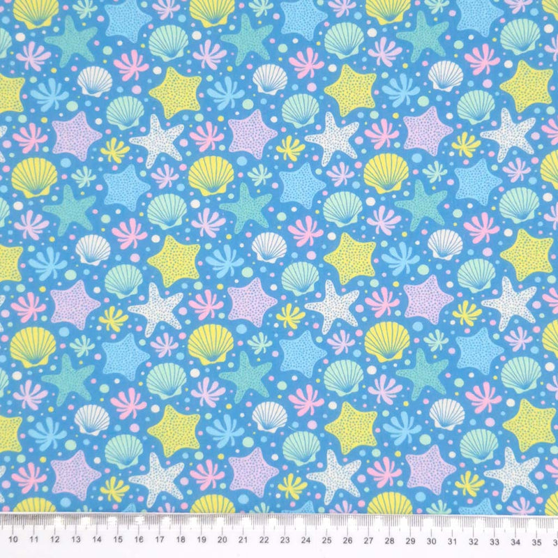 Starfish printed on a blue polycotton fabric with a cm ruler