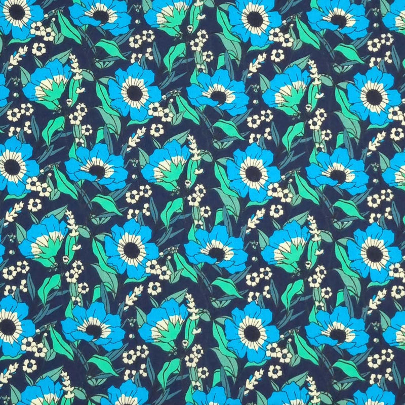 Blooming turquoise flowers are printed on a navy polycotton fabric