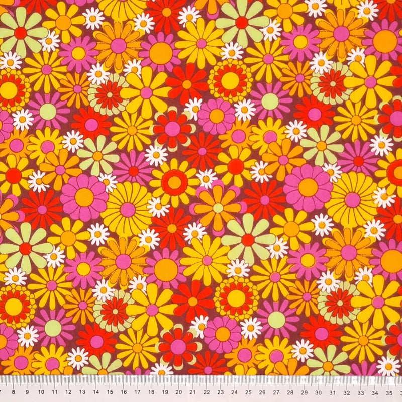 Colourful flowers with a retro vibe are printed on a brown coloured polycotton fabric with a cm ruler