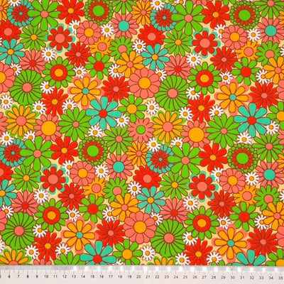 Colourful flowers with a retro vibe are printed on a sand coloured polycotton fabric with a cm ruler