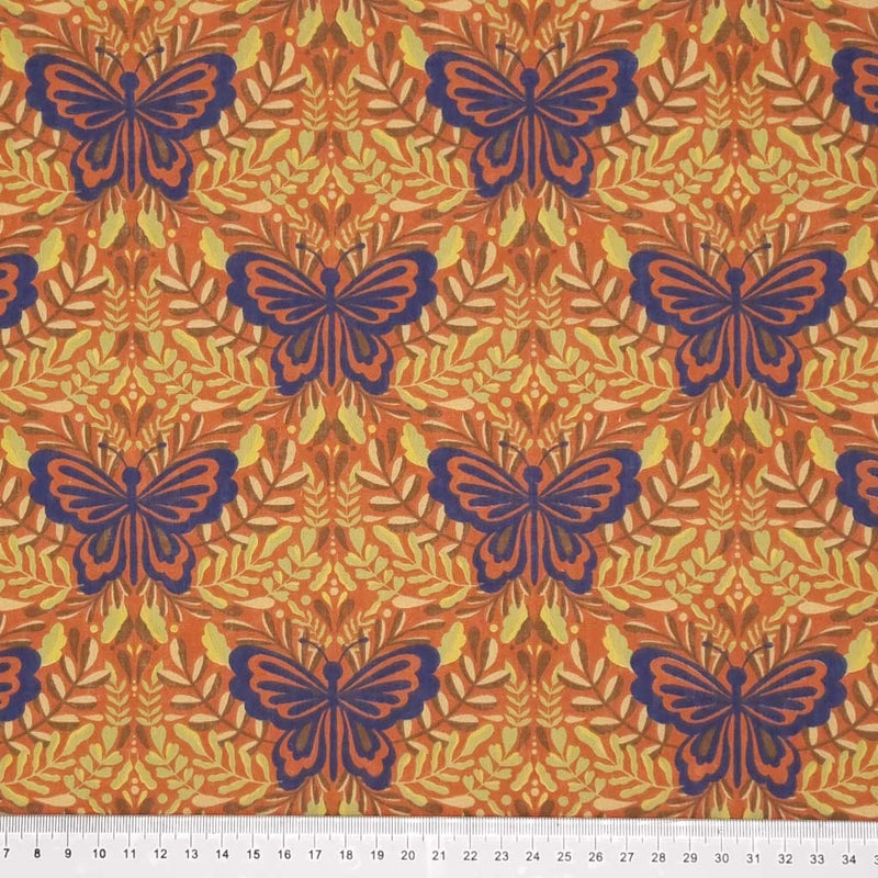 Large butterflies in purple are printed on a rust coloured polycotton fabric with a cm ruler