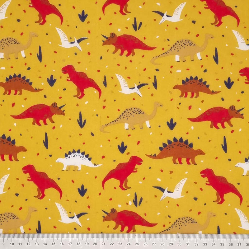 Red and brown dinosaurs printed on a mustard yellow polycotton fabric with a cm ruler