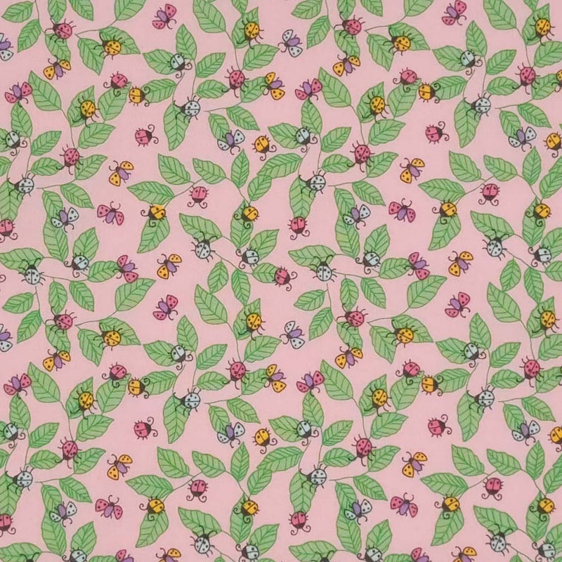 Pink and yellow ladybirds printed on a pink polycotton fabric