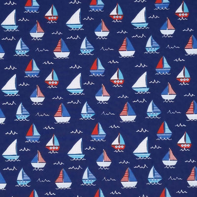 Red, white and blue sailing boats printed on a navy polycotton fabric