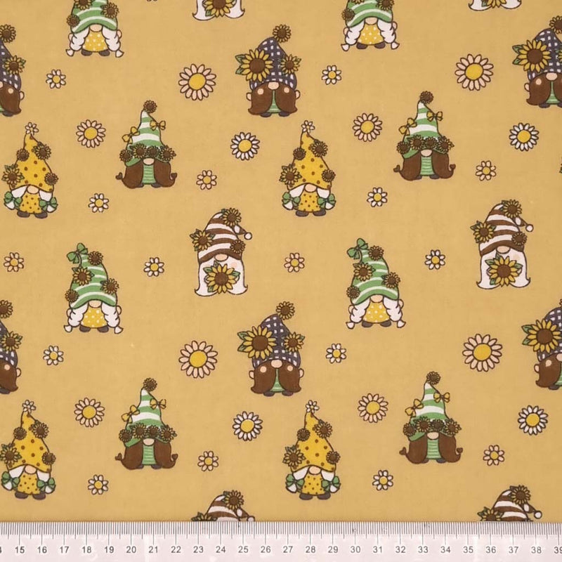 Cute little gonks with daisies are printed on a camel coloured polycotton fabric with a cm ruler