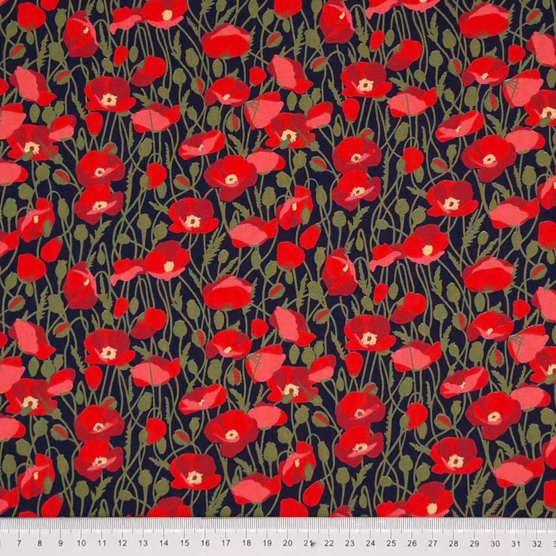 Red poppies printed on a navy cotton poplin fabric by Rose & Hubble with a cm ruler