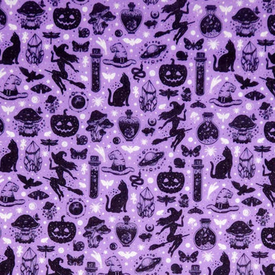 Black Halloween-themed silhouettes including cats, pumpkins, and witches on a purple halloween polycotton fabric.