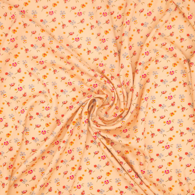 Floral patterned fabric with a swirl design on a peach viscose fabric