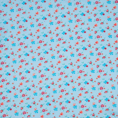 Floral patterned fabric with red and blue flowers on a light blue viscose fabric