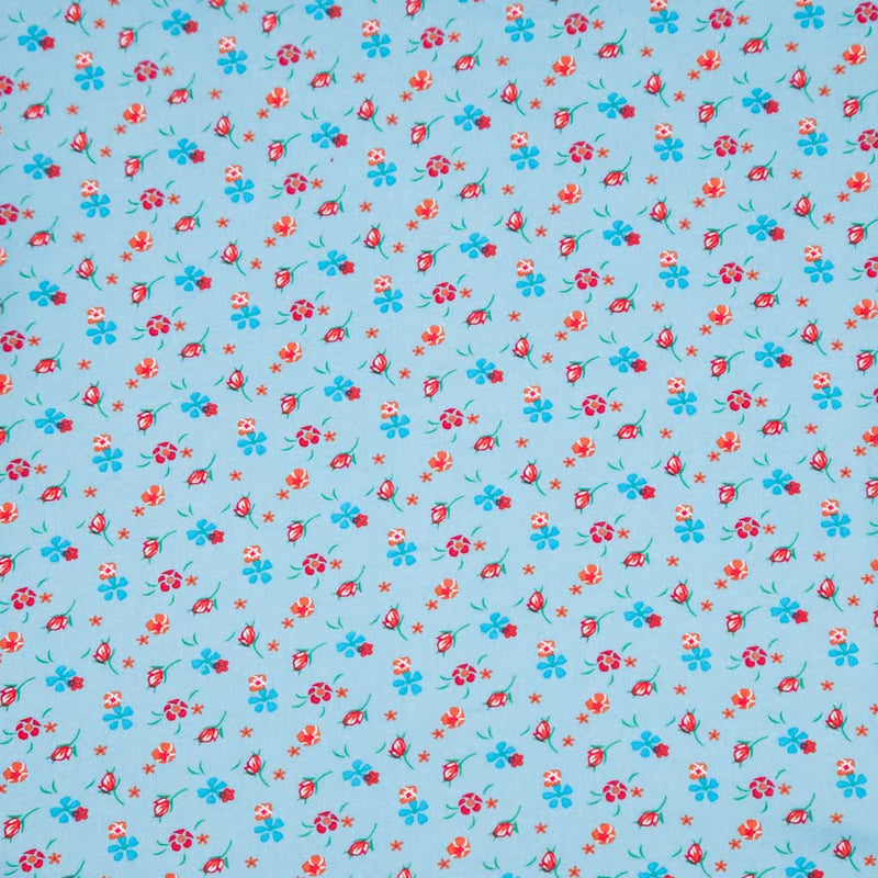 Floral patterned fabric with red and blue flowers on a light blue viscose fabric