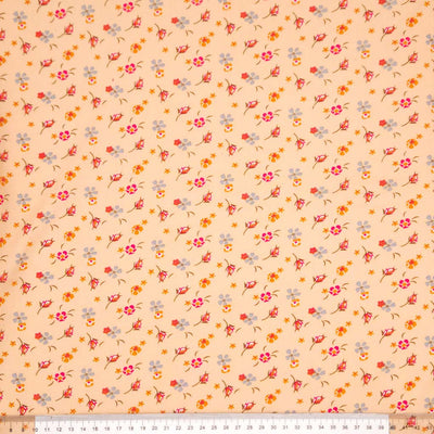 Floral patterned fabric with a swirl design on a peach viscose fabric with a ruler